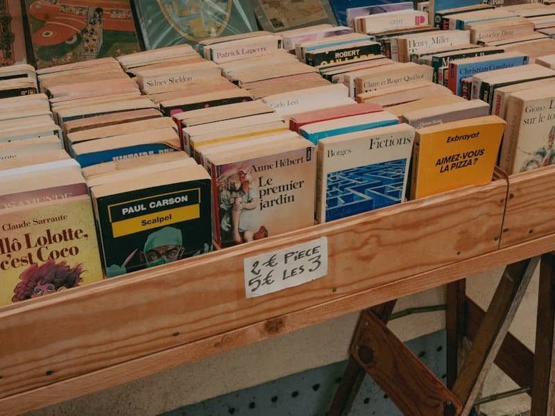 Second-hand books for sale on a wooden market stall.