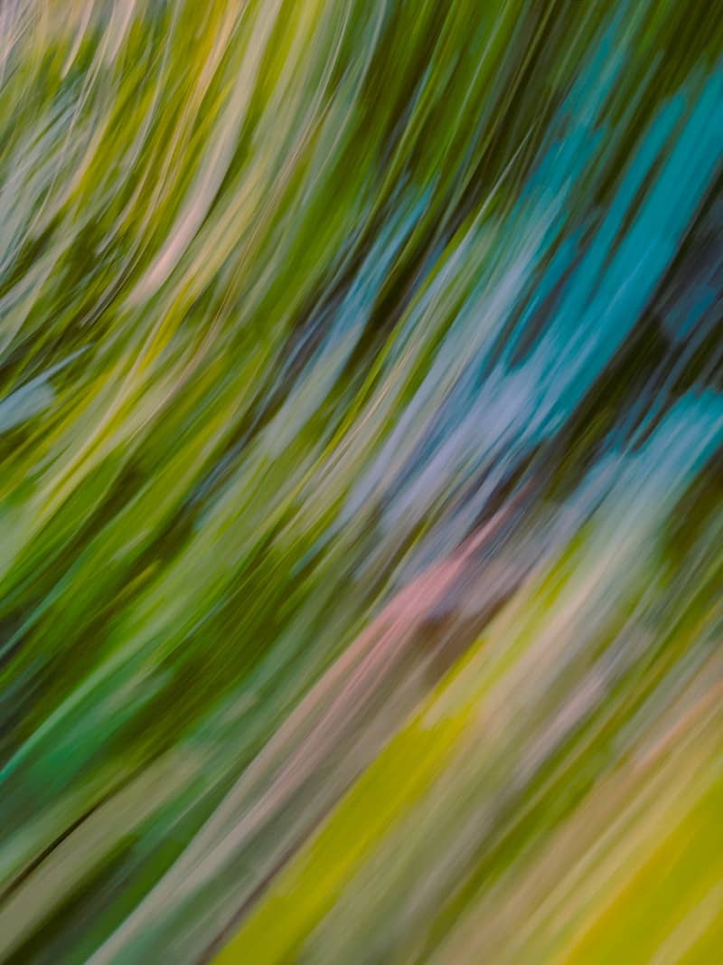 Abstract blurred streaks of green, yellow, and blue colors.