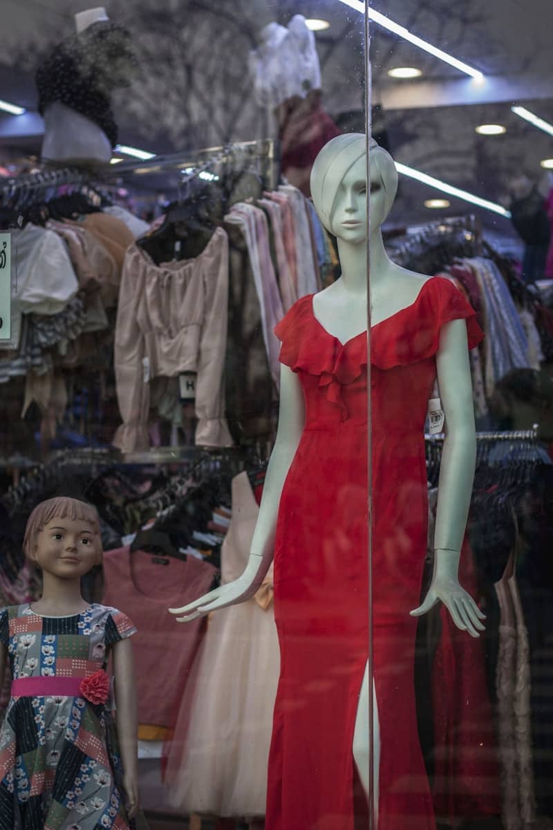 Mannequins in a store window displaying clothes