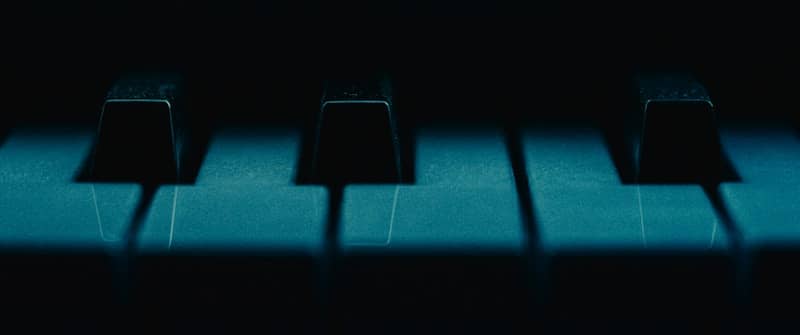 A close up of a piano keyboard in the dark
