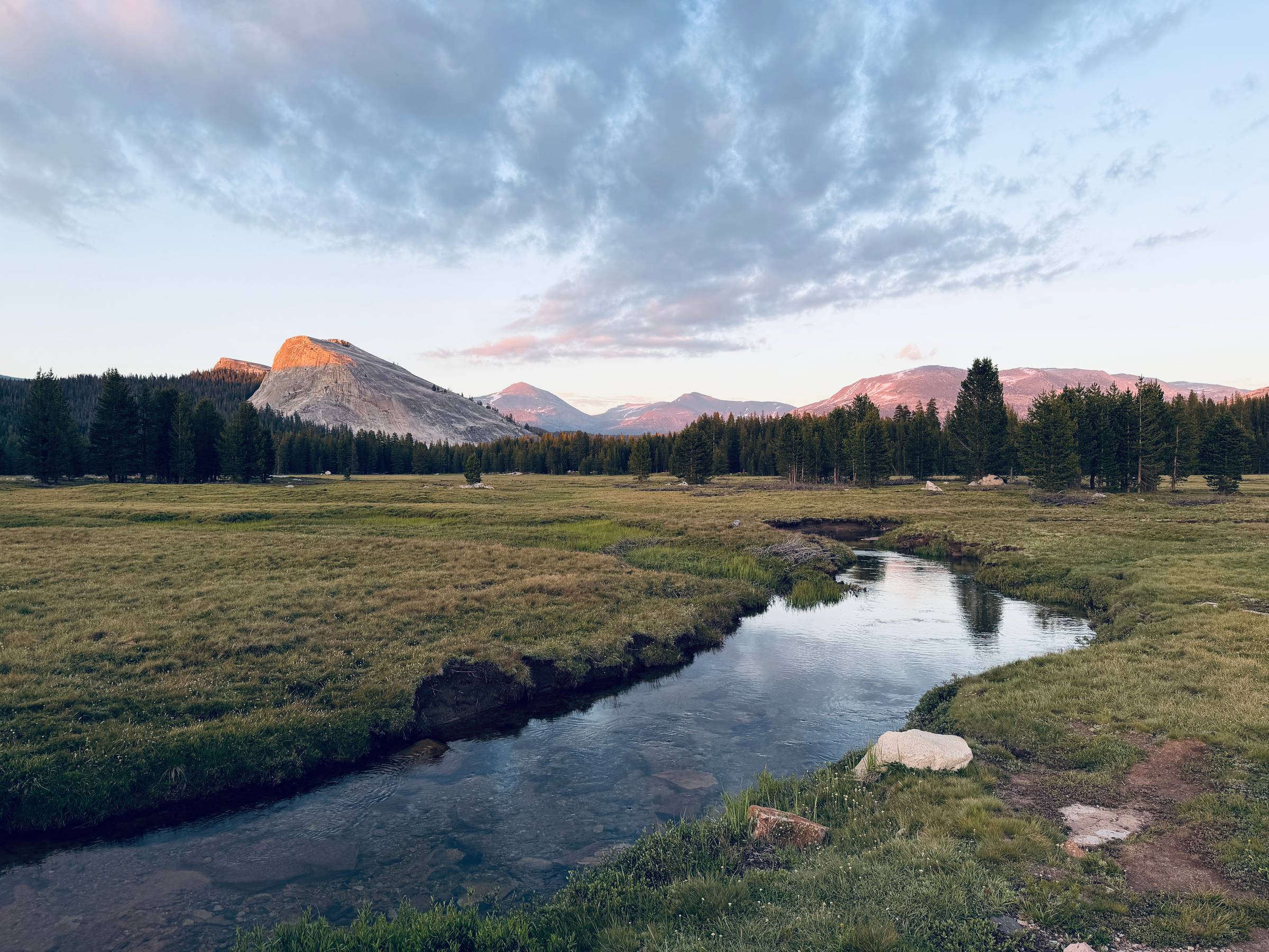 River runs though Tuolumne meadows in Yosemite at sunset.