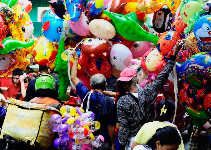 People gather amidst a vibrant array of balloons.
