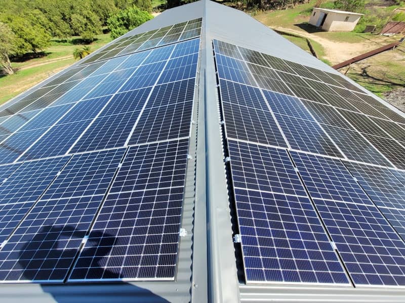 Solar panels installed on a grey corrugated metal roof.