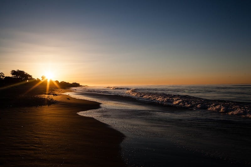 日落時海浪撞擊岸邊