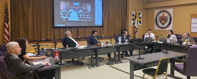 county commissioners listen to county staff explain health insurance cost increase