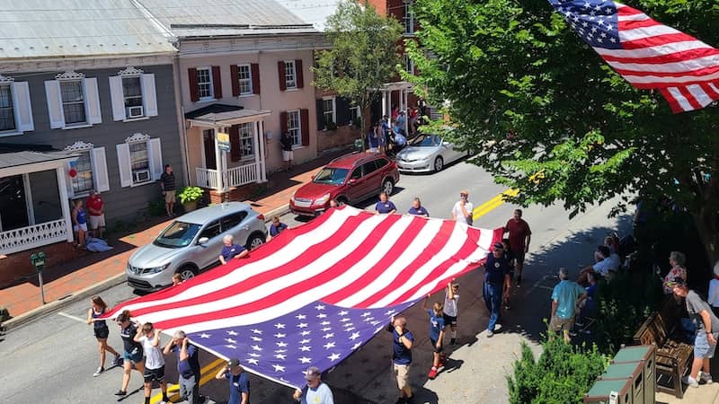 volunteers carry large flag in parade