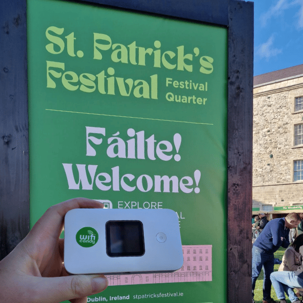 a person holding a portable device in front of a sign