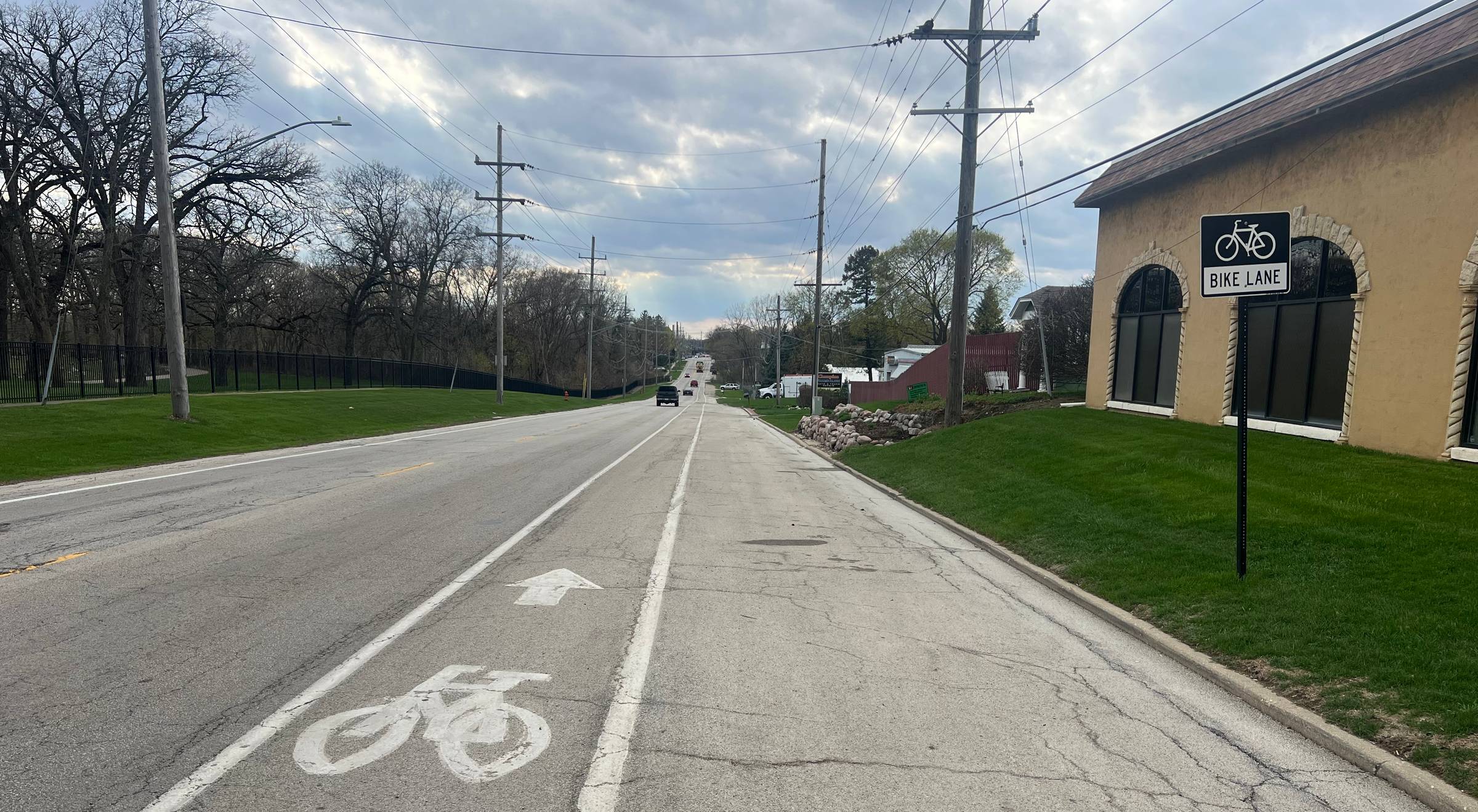 Looking down a bike lane on a paved road through an industrial area