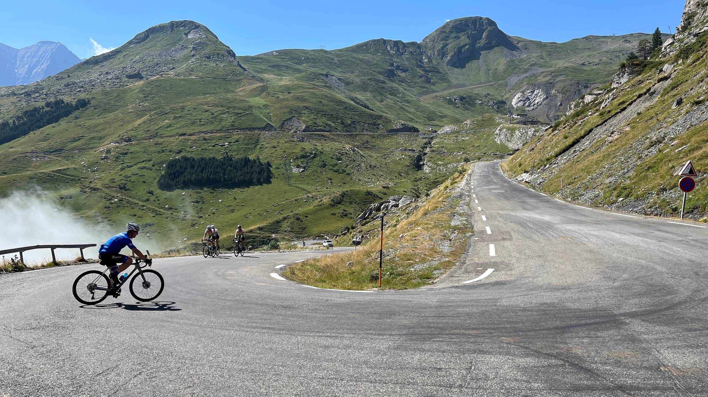 Looking down and up a switchback in a hot green mountain pass