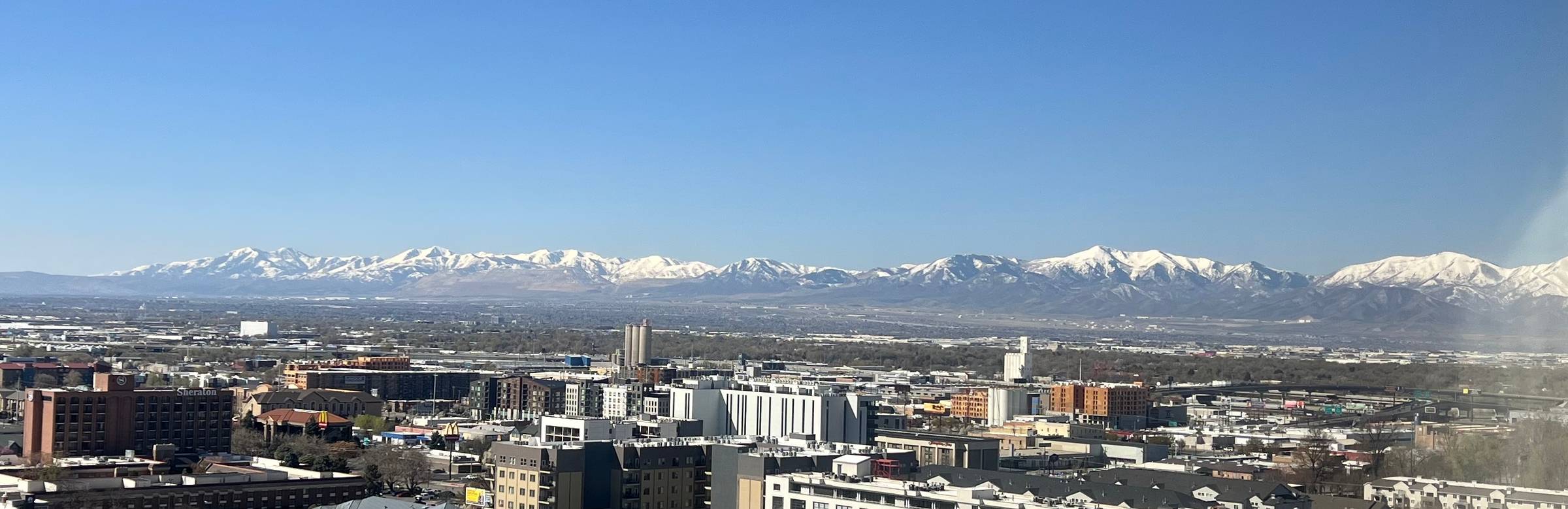 A view of snow-capped mountains with a city in the foreground