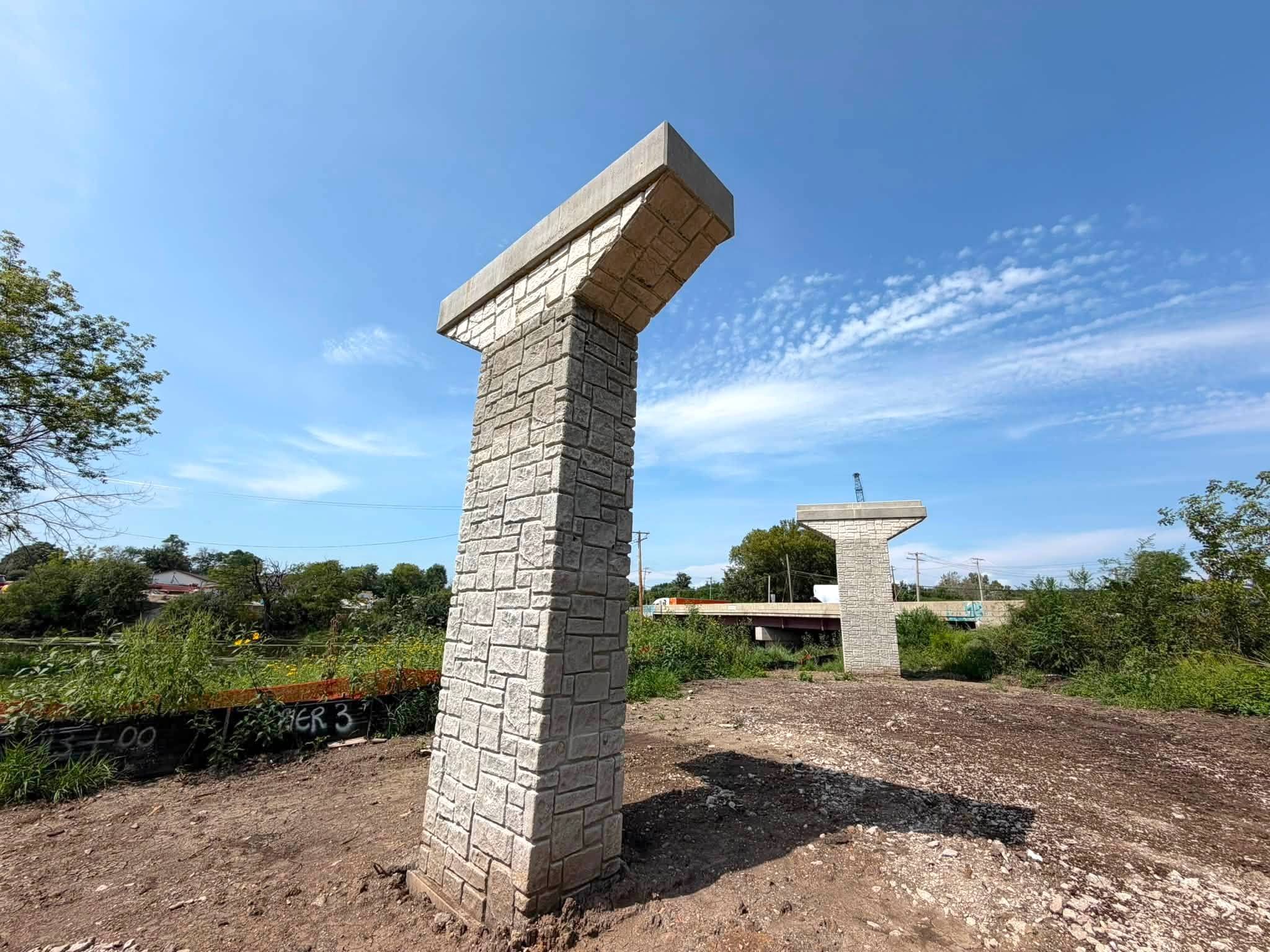 Construction site with concrete bridge pier structures in an open suburban spot.