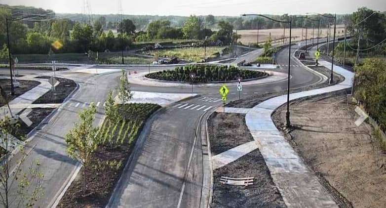 Roads and paths lead to and through a roundabout in the middle of a rural area.