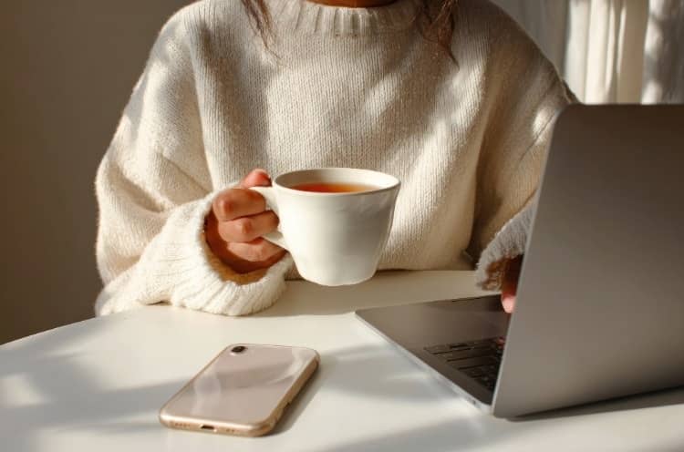 A writer working on her laptop. The image illustrates the current situation of being a writer and dealing with the new AI mode take over.