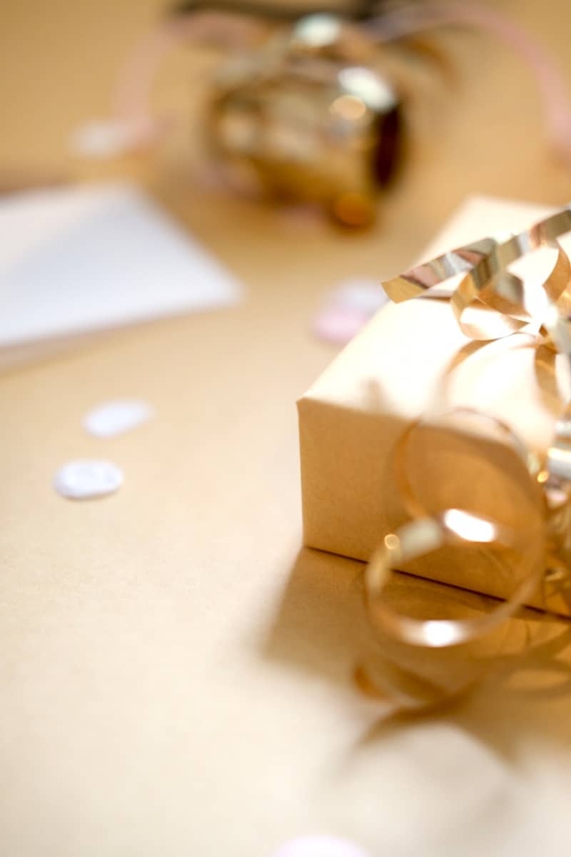 A gift box with golden ribbon and confetti