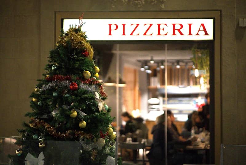 A christmas tree is in front of a restaurant