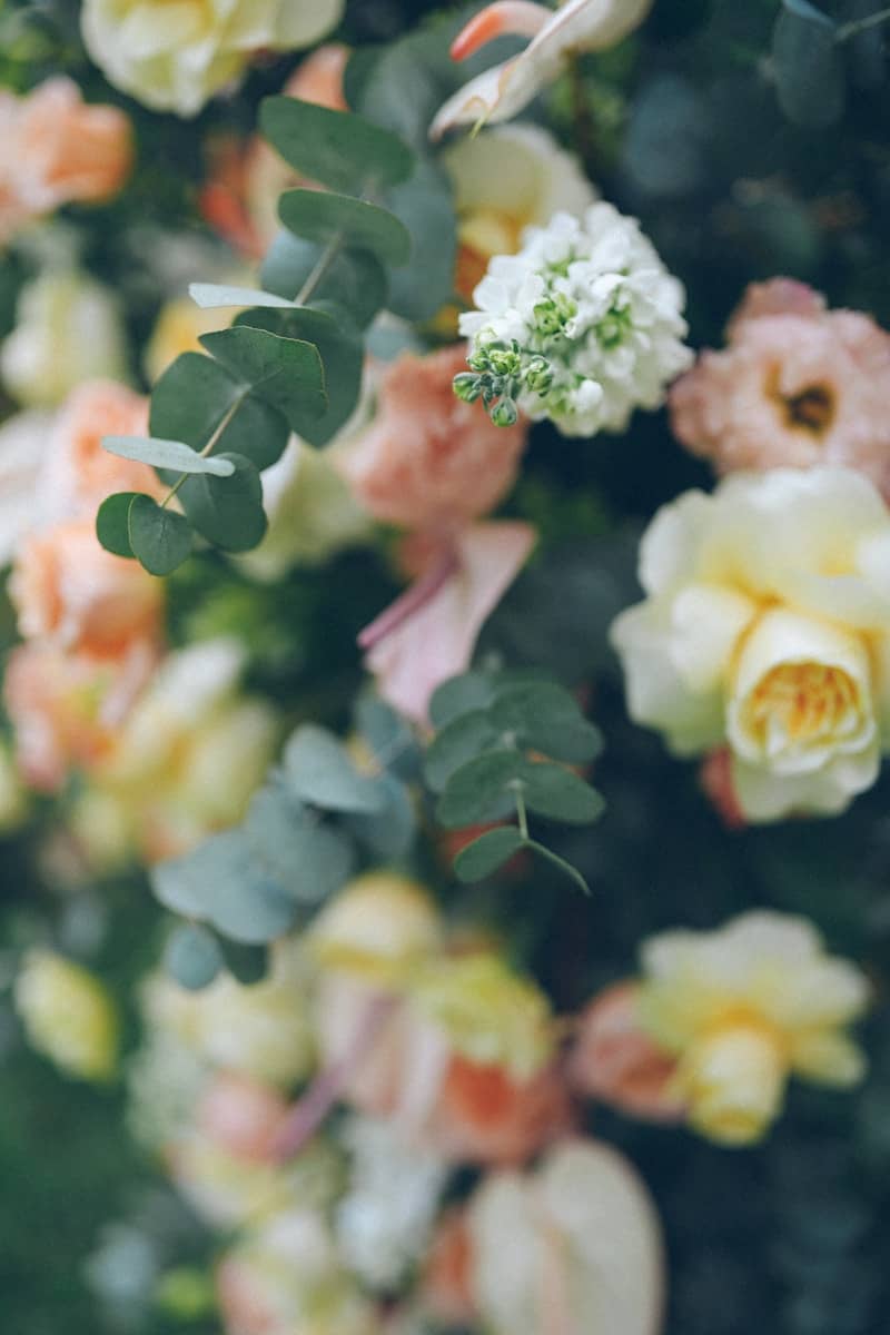 A close-up of a floral arrangement with roses and eucalyptus.