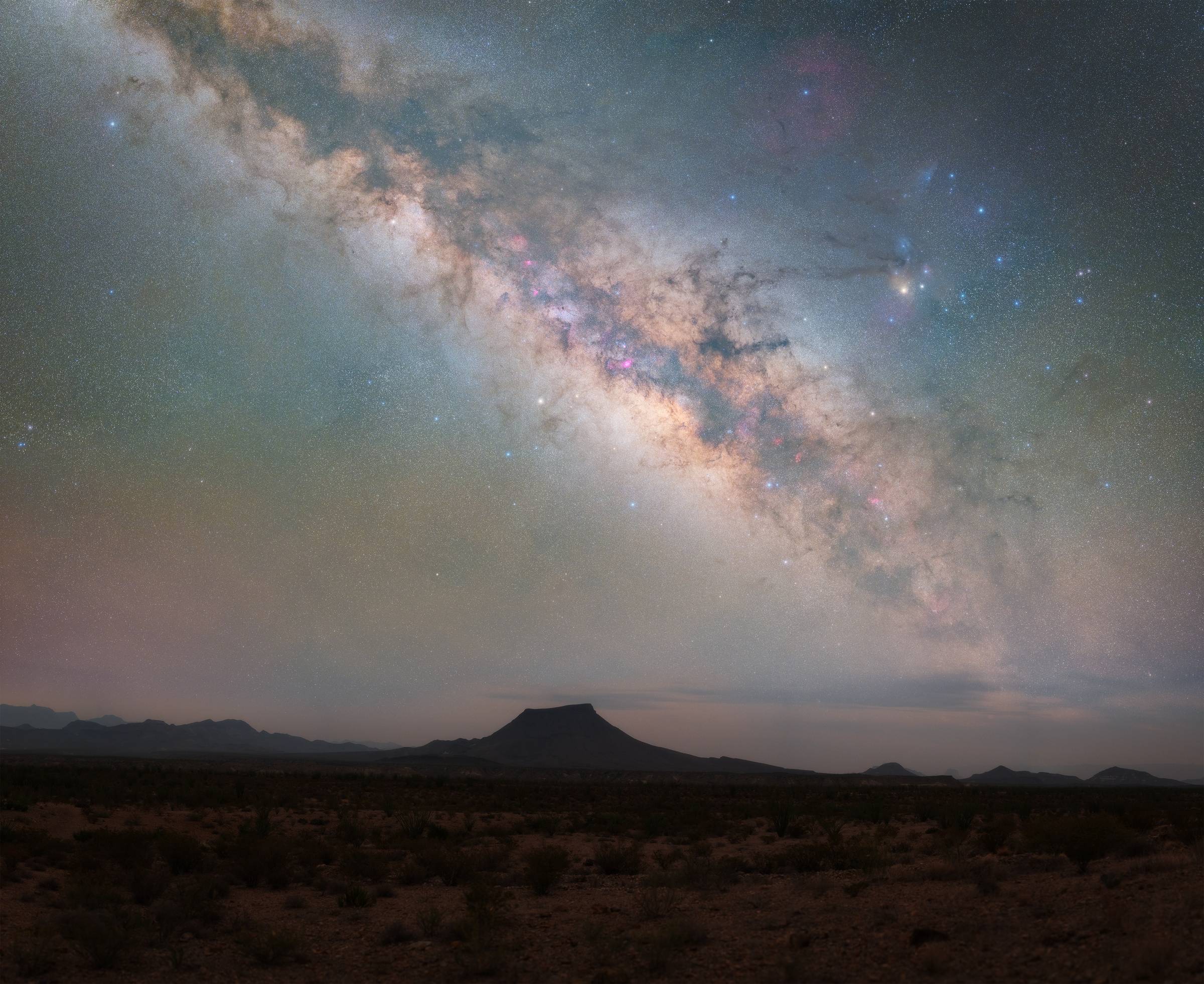 milky way core over a desert landscape