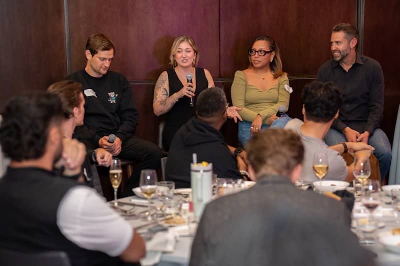 Panel discussion with speakers and audience at a table.