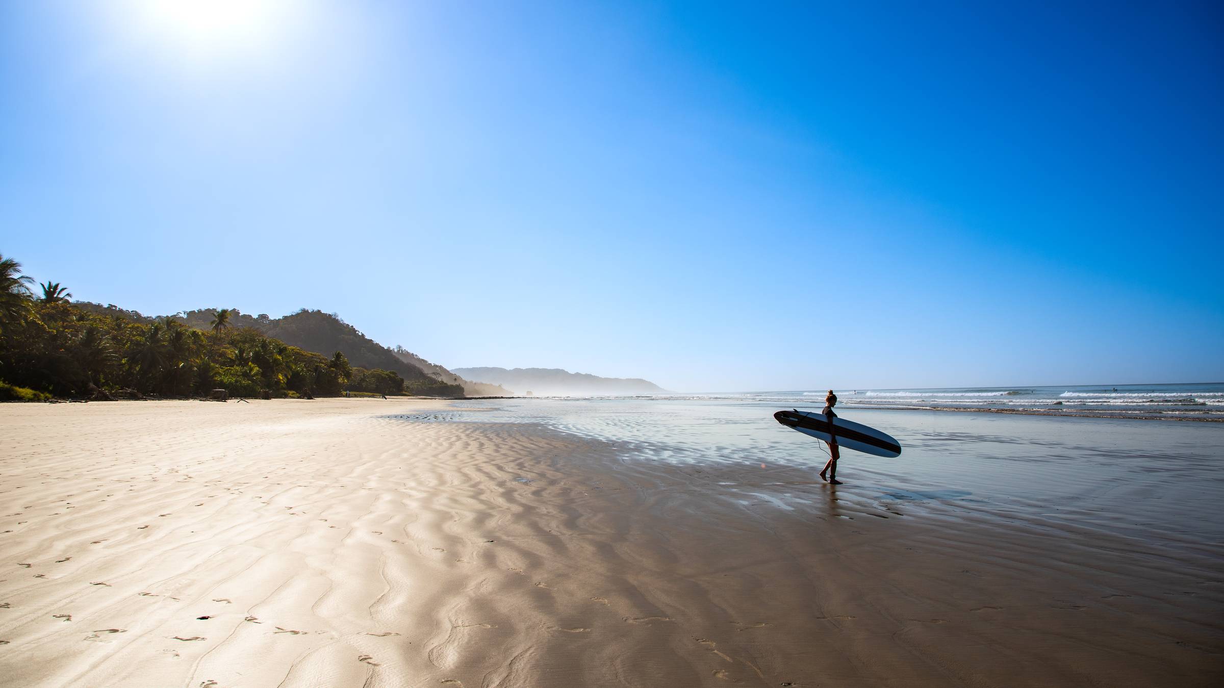 Lone Surfer on the Beach in Santa Teresa