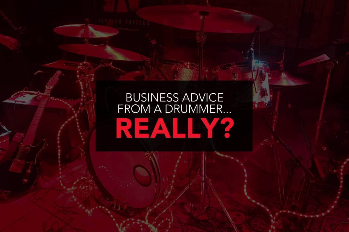 Photo of a sparkly drum kit under red lights. Over the image is bold text that reads "Business advice from a drummer... really?" 