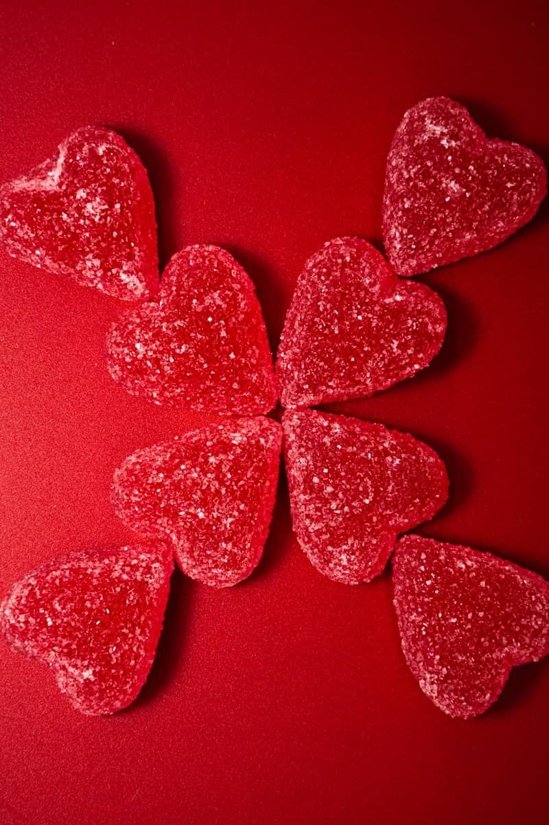Red heart-shaped candies arranged on a red background