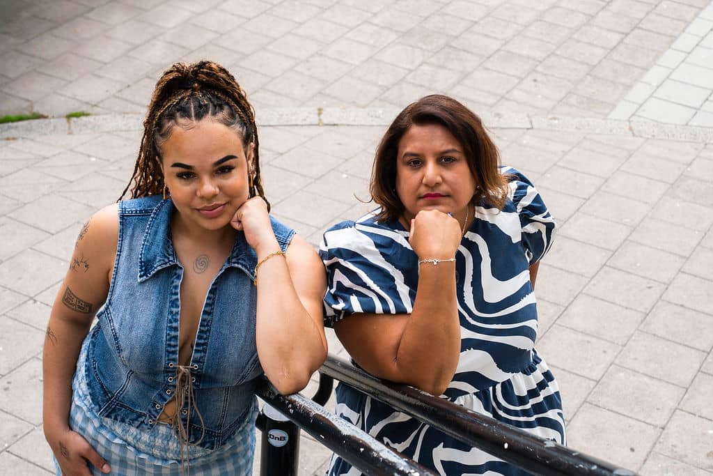 Mo and Kaia with arms under chin looking serious