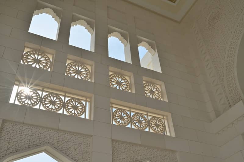 Sunlight streams through ornate windows of a building.