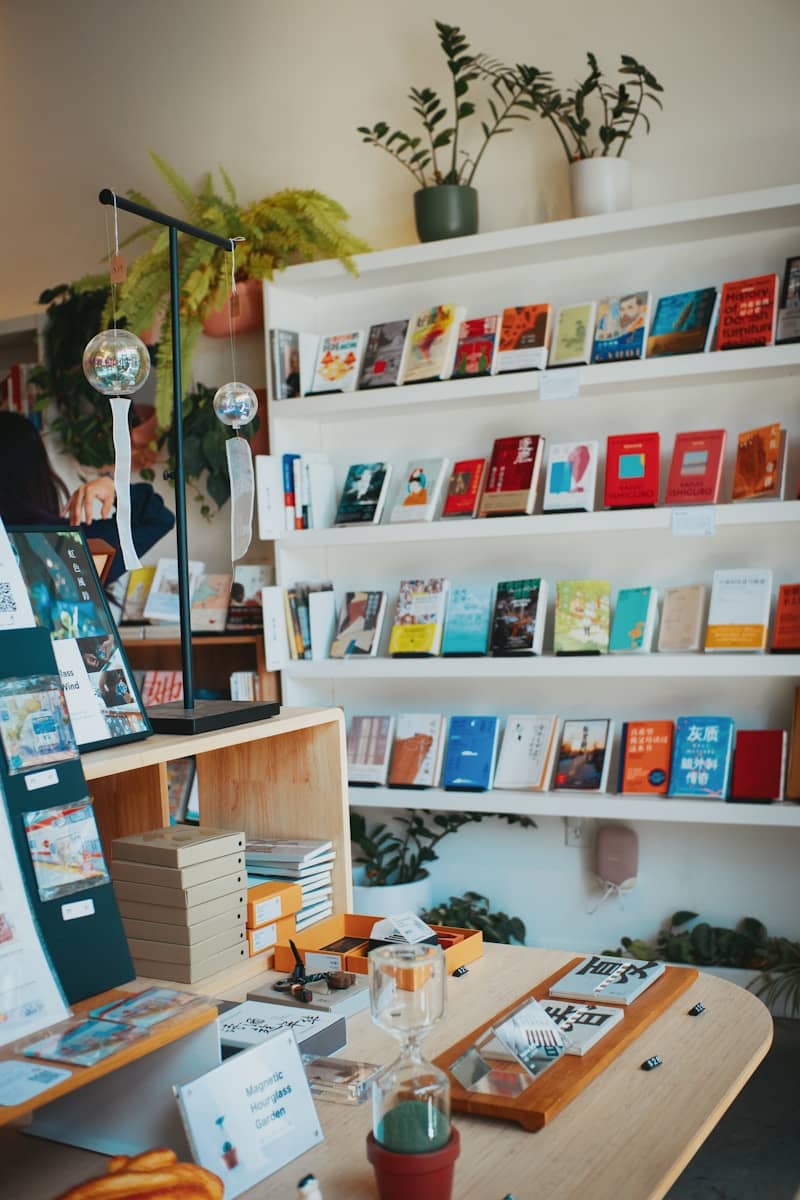 Books on white shelves and a wooden table in a bright bookstore