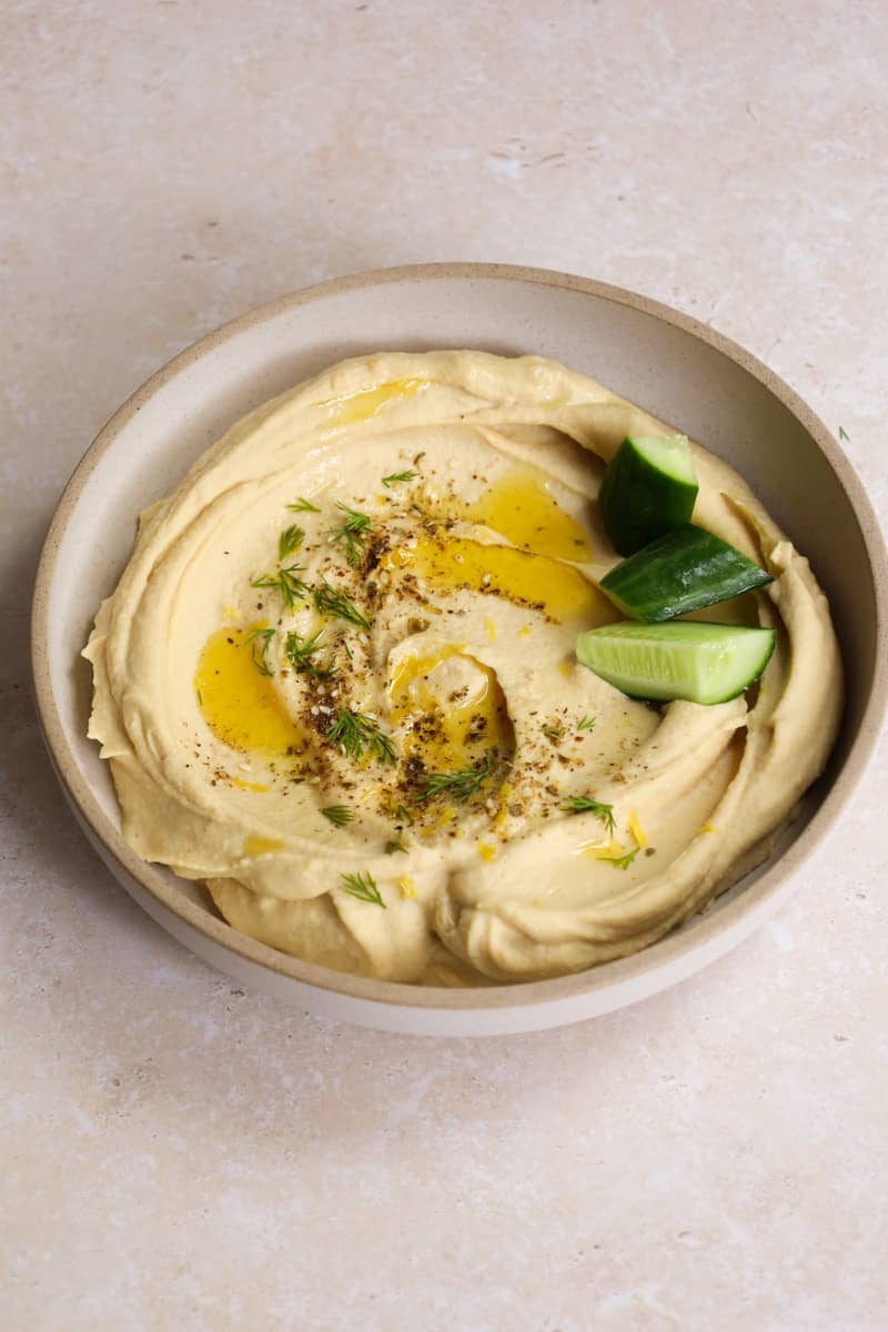 Creamy hummus with olive oil and cucumber.