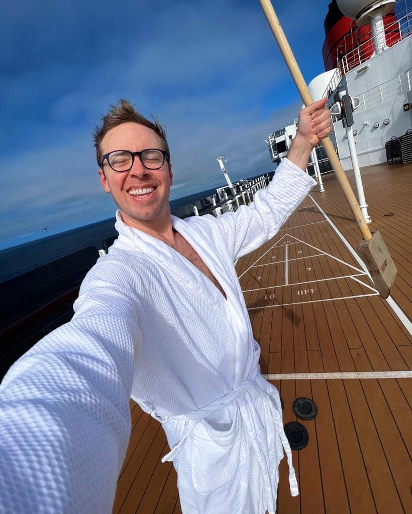 selfie photo of a man wearing a white bathroom on a cruise