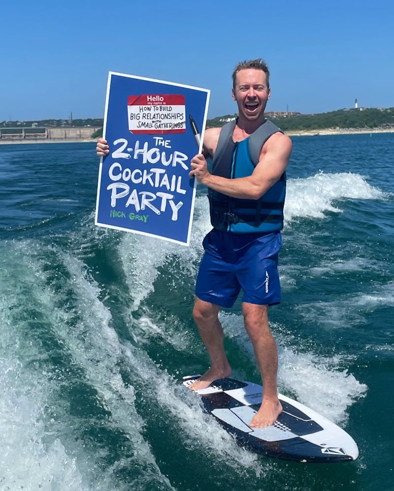 photo of my wakesurfing while holding a poster of my book cover