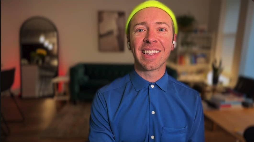 Nick Gray wearing a blue button down shirt and a neon yellow beanie