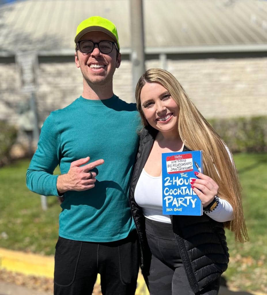 Nick Gray (left) pointing to Elle (right) while holding a book called The 2-Hour Cocktail Party