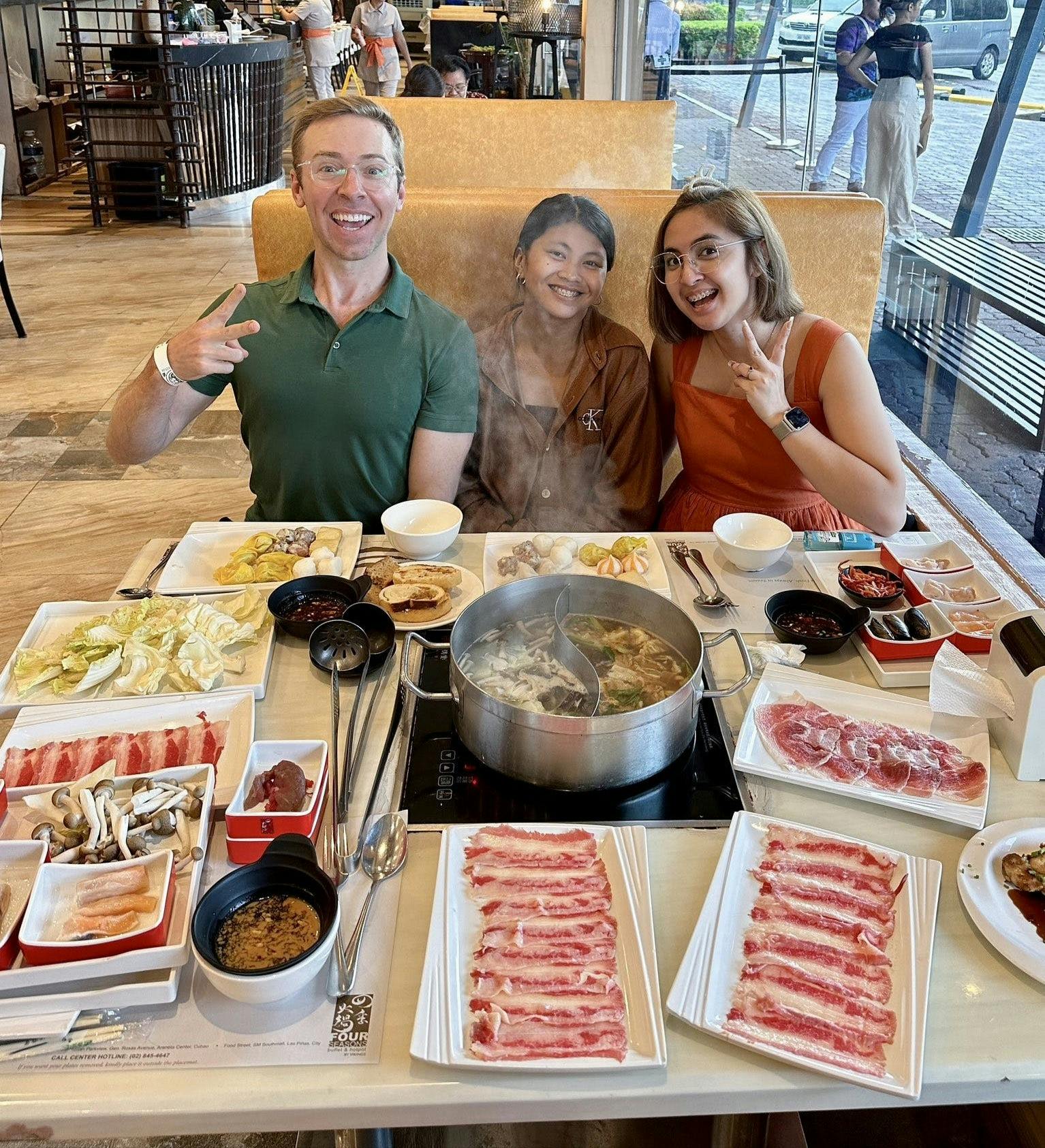 A photo of Nick Gray and his assistants sitting in front of a hotpot table
