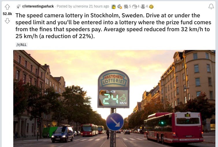 A road in Stockholm with cars, buses and buildings.