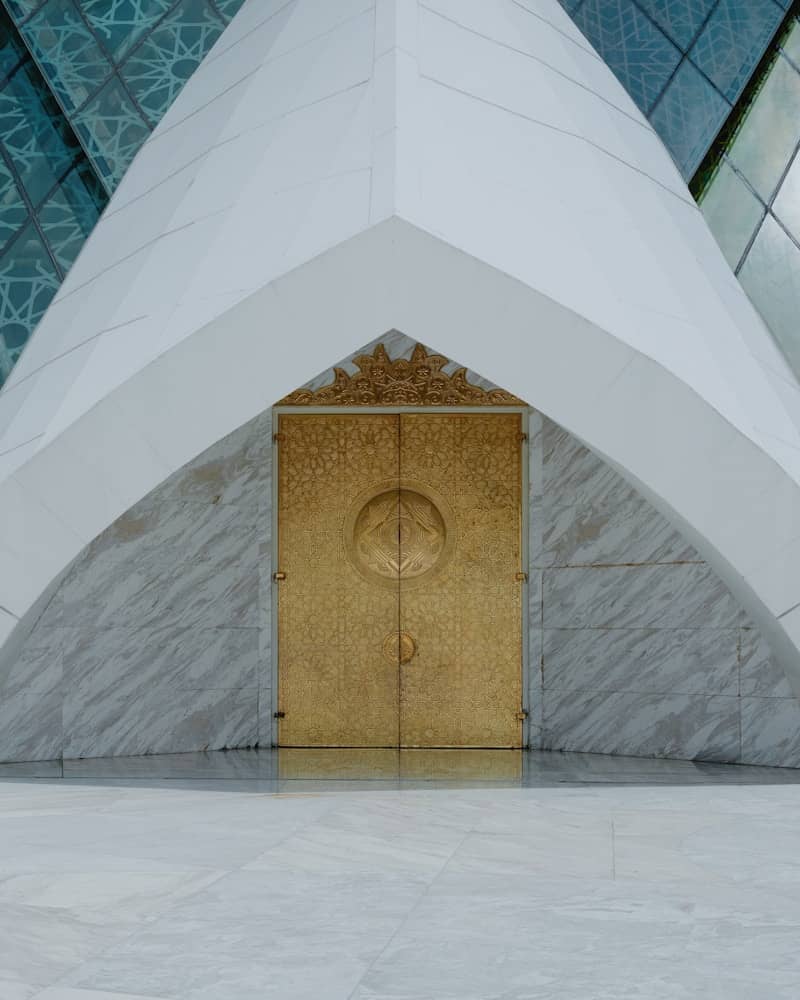 Ornate golden doors set in a modern architectural facade