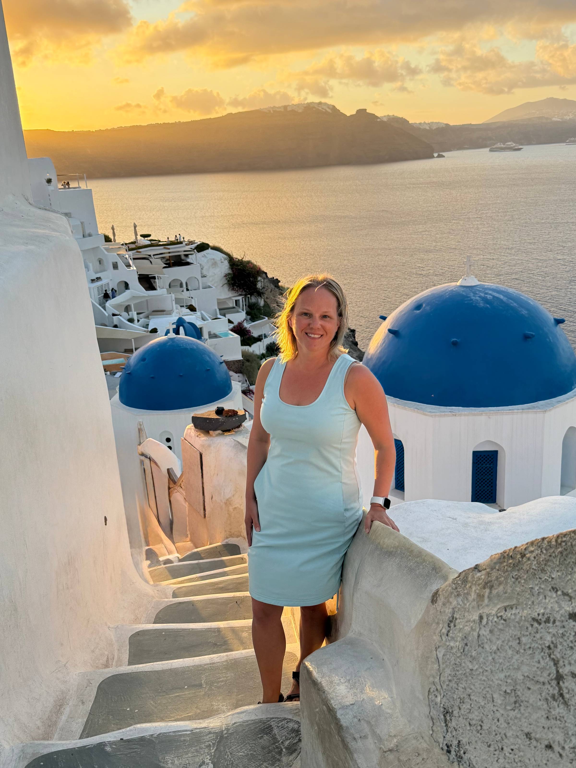 Rachel at the blue domes in Santorini at sunrise