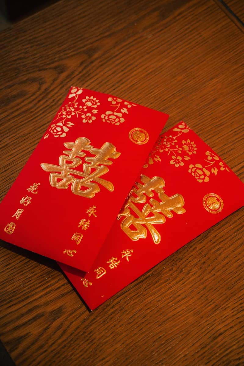 A couple of red envelopes sitting on top of a wooden table