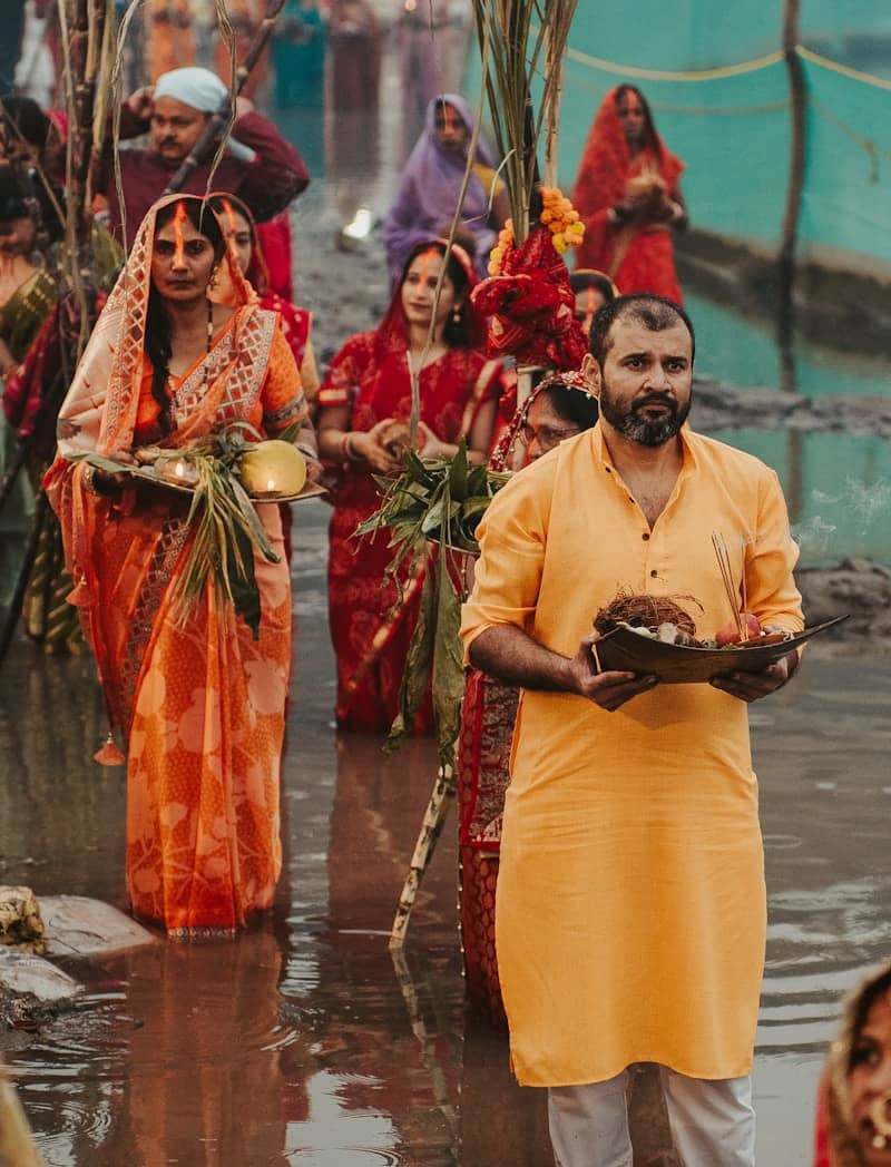 People in traditional indian attire carrying offerings