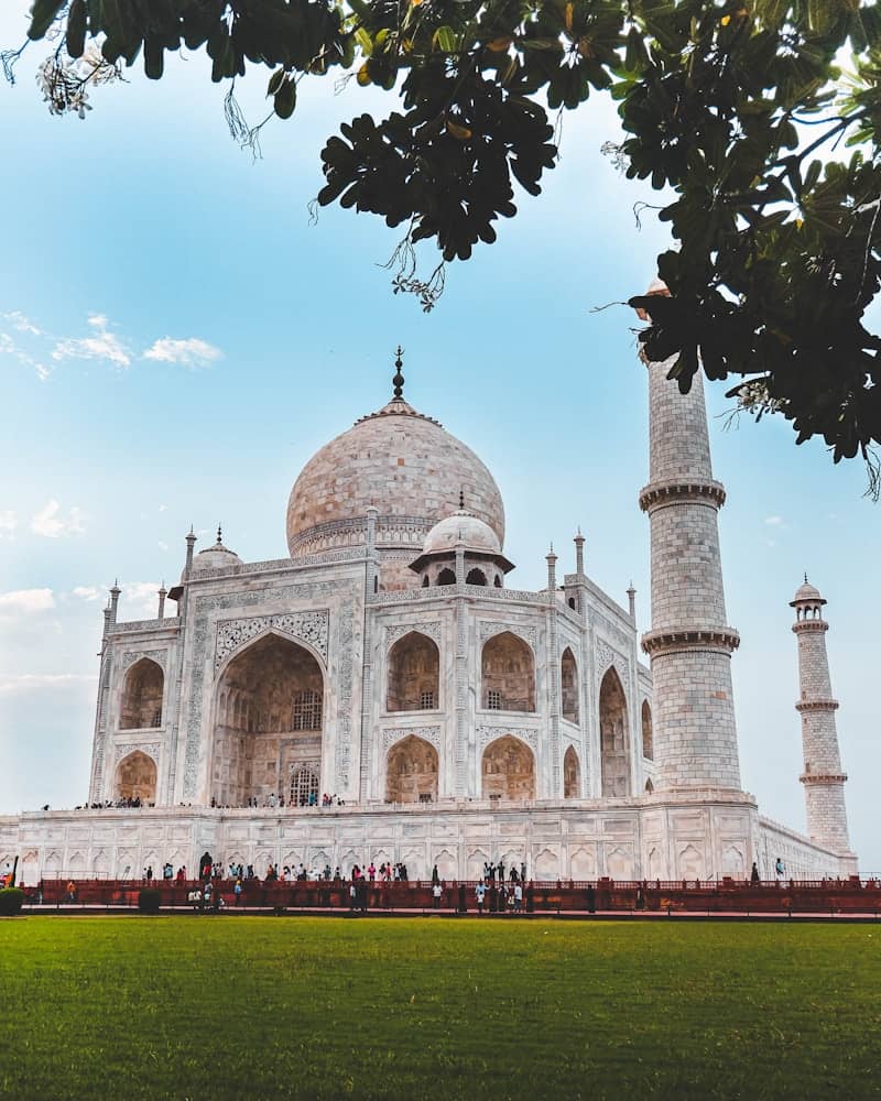The taj mahal mausoleum under a bright blue sky.