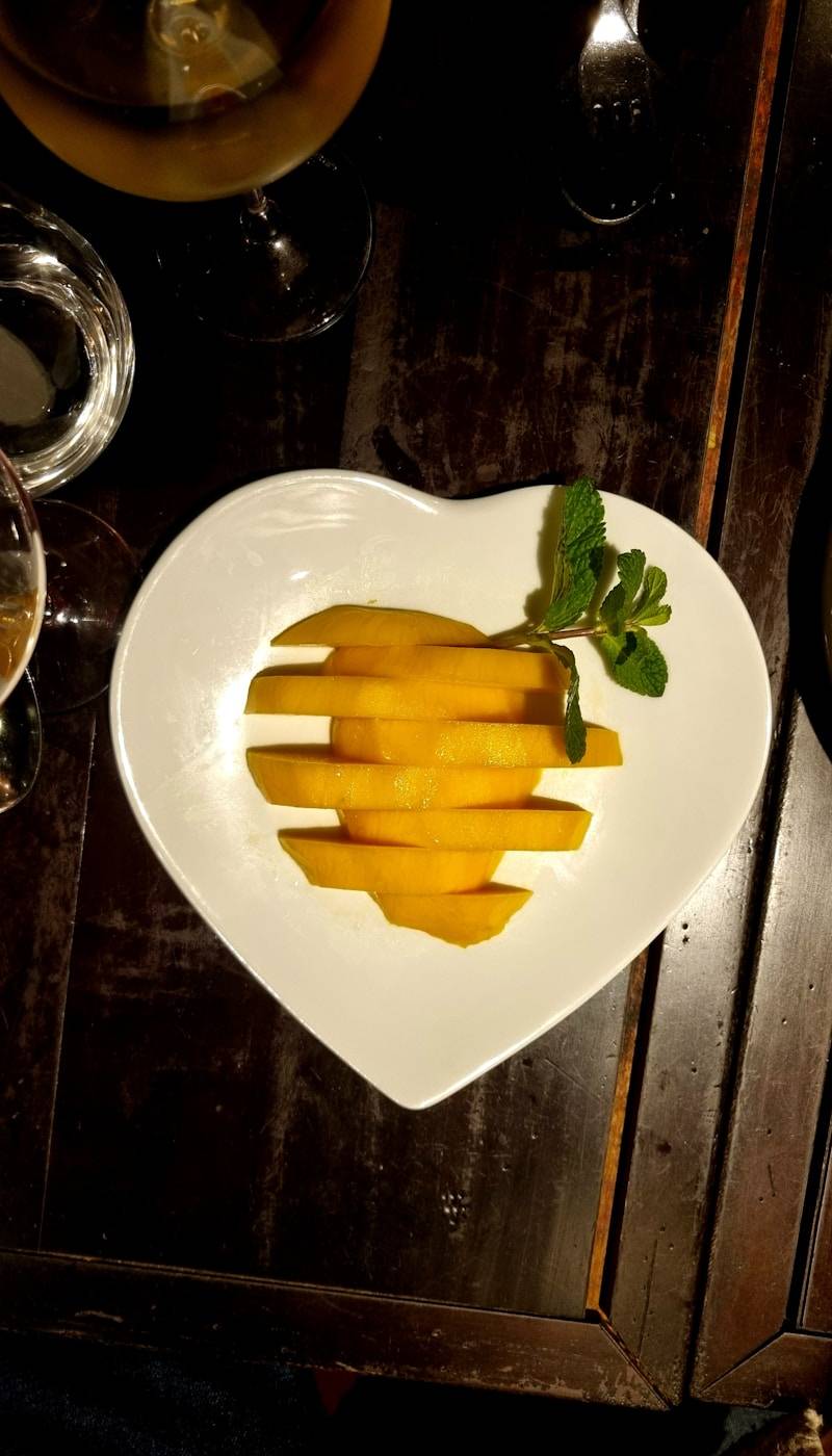 Sliced mango on a heart-shaped plate.
