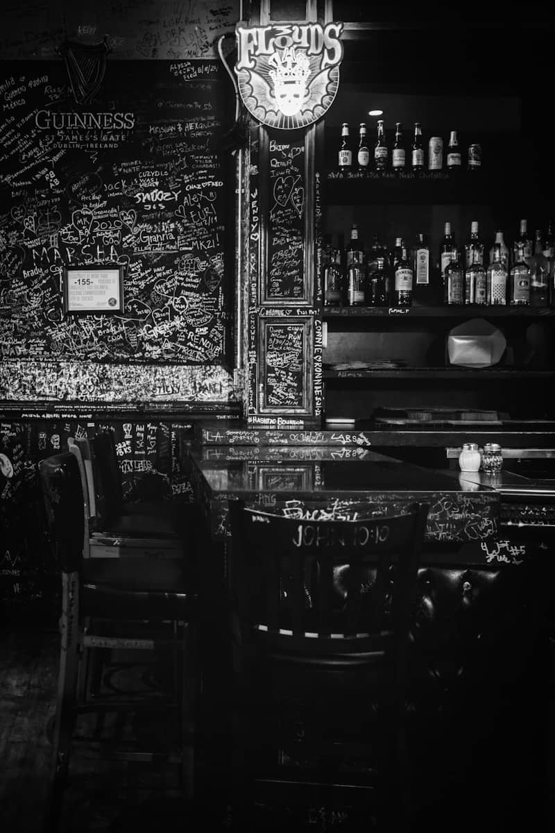 An old, dimly lit bar in black and white.