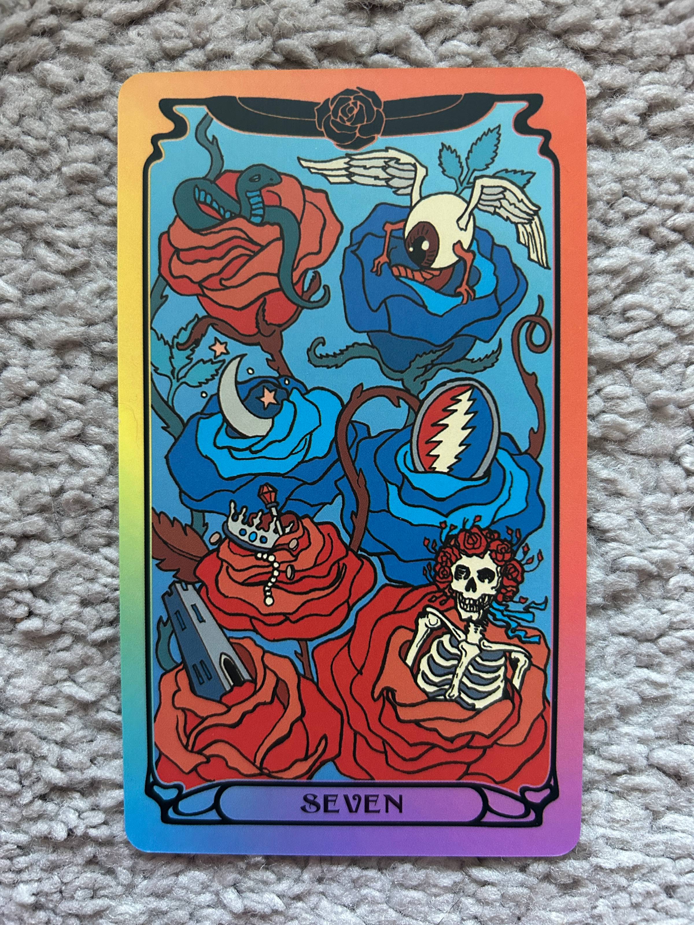 A photo of a tarot card featuring roses, a skeleton, and the Grateful Dead logo.