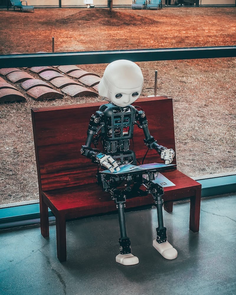 Black and white robot toy on red wooden bench