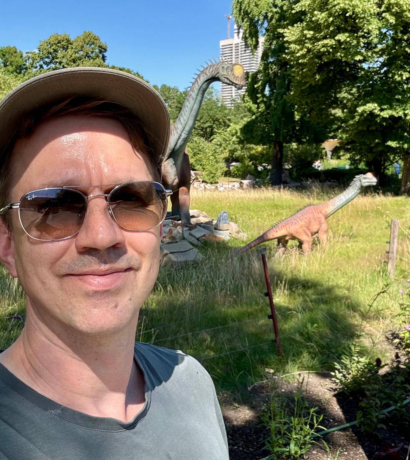 Ein Mann vor 2 Dino-Skulpturen