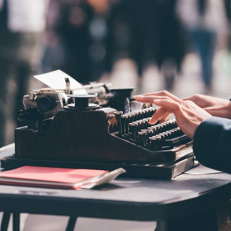 person using black typewriter