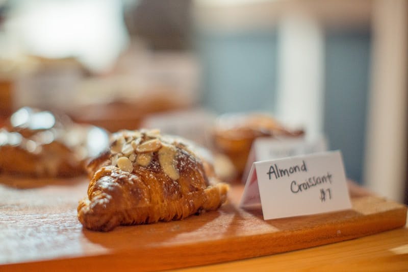 A wooden table topped with lots of pastries