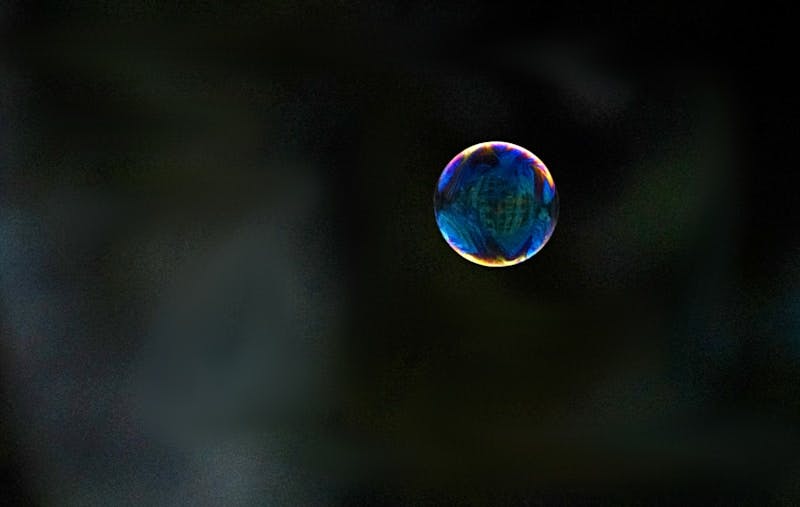 A soap bubble floating in the air with a blurry background