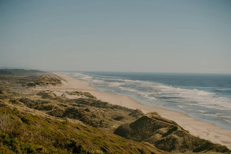 Vast sandy beach with ocean waves and rolling dunes