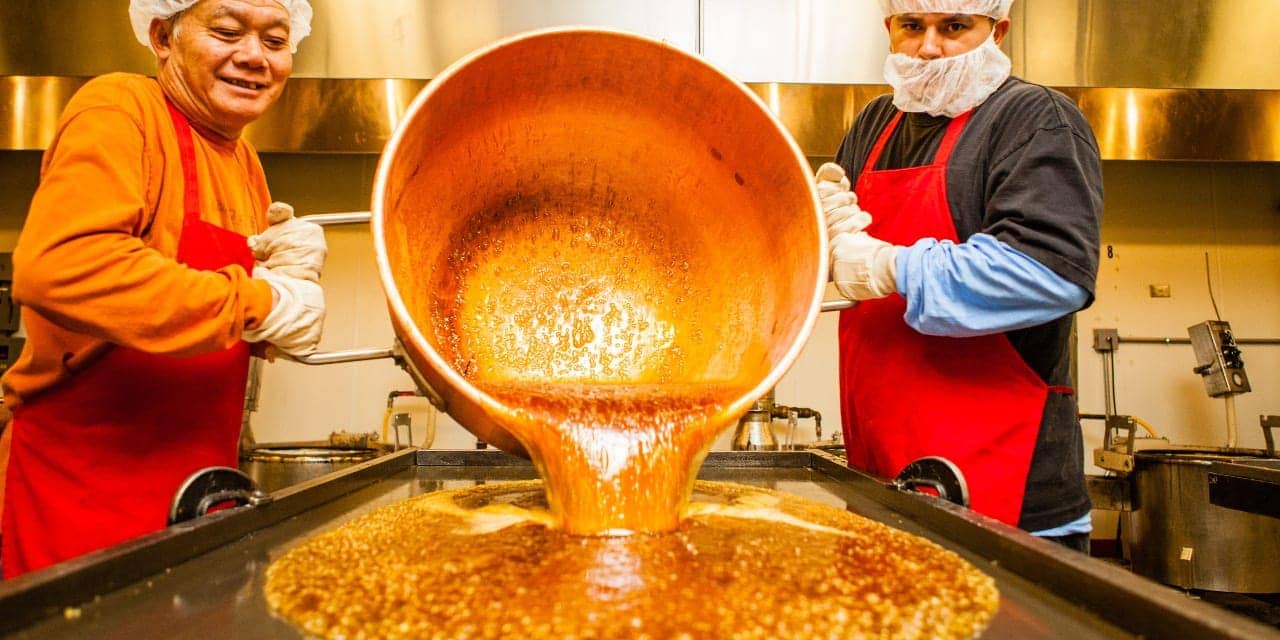 two men pour hot candy at Hammond's Candies in Denver